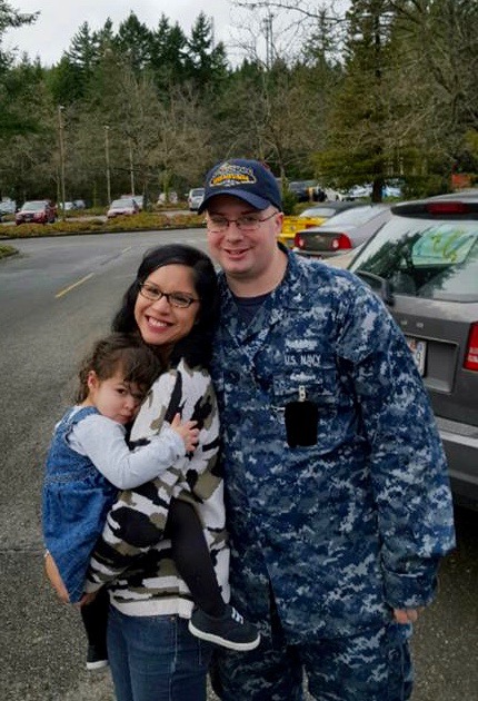 Aaron, just home from his last deployment, with his wife and daughter. With his Navy stint drawing to a close, he and his family will soon be sailing uncharted waters.